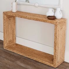 a white vase sitting on top of a wooden shelf next to a mirror and vase