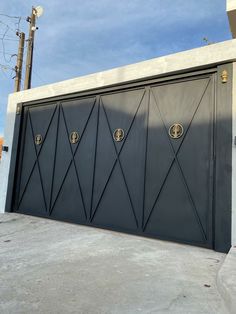 a black garage door with two gold emblems on the front and side doors,