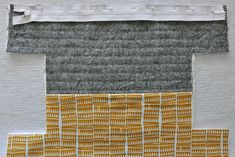 an art piece with yellow and grey squares on it