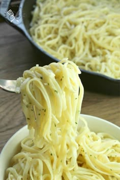 a spoon full of spaghetti being held by someone