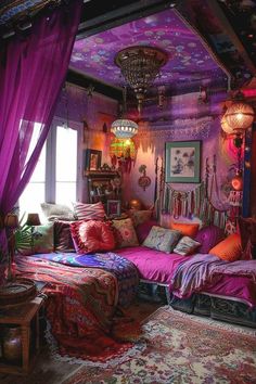 a bedroom decorated in purple and pink with lots of pillows on the bed, lights hanging from the ceiling