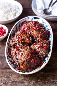 meat with pomegranates in a bowl on a wooden table