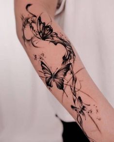 a woman's arm with black and white butterflies on the back of her arm