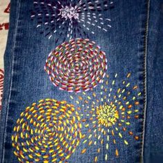 an old pair of jeans with colorful designs on them