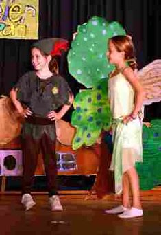 two children are standing on stage with their arms around each other