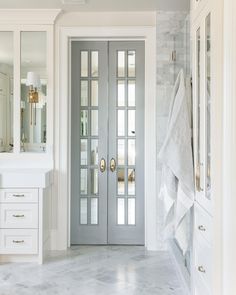 a bathroom with marble floors and double doors