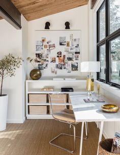 a room with a desk, chair and pictures on the wall above it is also a window