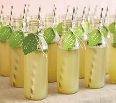 there are many jars with straws in them and some green leaves on the top