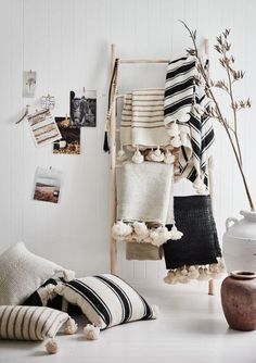 a white room with black and white accessories hanging on the wall next to a vase