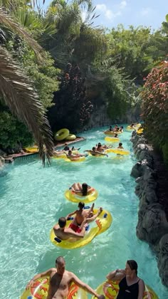 several people are floating down a river on rafts in the middle of an outdoor swimming area