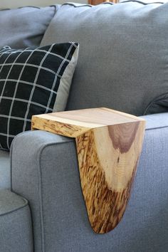 a wooden table sitting on top of a gray couch