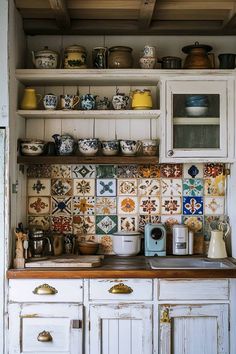 a kitchen with white cabinets and colorful tile backsplashes on the counter top