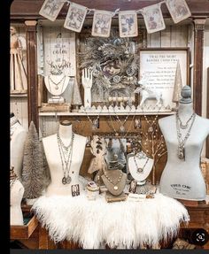 a display case filled with mannequins and necklaces on top of a table