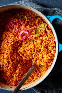 a pot filled with rice and onions on top of a table