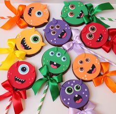 there are many decorated cookies with eyes and bows on the table next to each other