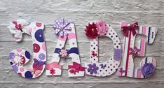 the word daisy is made out of paper and decorated with pink, purple, and white flowers