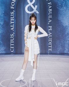 a woman standing in front of a blue and white sign