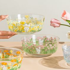 three glass bowls with flowers painted on them