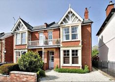 a red brick house with white windows and balconies