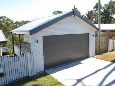 a white house with a grey garage door