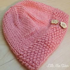 a pink knitted hat with buttons on it