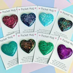 five heart shaped brooches are shown in different colors and sizes, with the words pocket hug on them