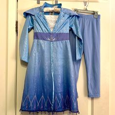 a blue dress and pants hanging on a door