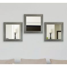 three mirrors hanging on the wall above a couch