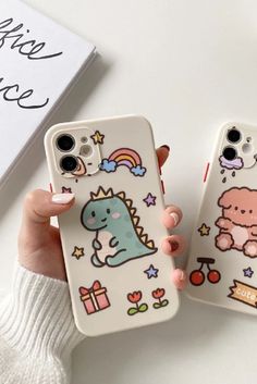 two phone cases with cartoon stickers on them