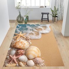 a rug with seashells and starfish on the beach in front of a window