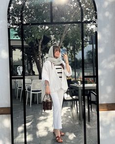 a woman taking a selfie with her cell phone in front of an outdoor dining area