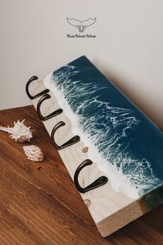 a cake with the word cocoa on it sitting on a wooden table next to seashells