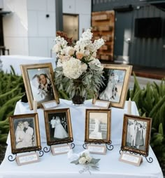 a table topped with pictures and flowers on top of a white cloth covered tablecloth