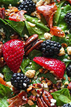 spinach salad with berries, pecans, walnuts and feta cheese on top