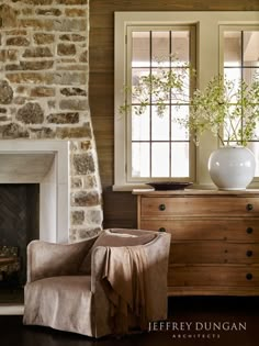 a living room filled with furniture and a fire place in front of a stone fireplace