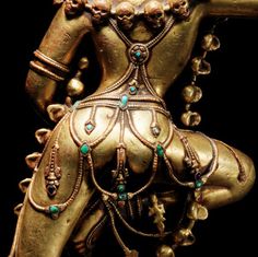 a gold statue with green beads on it's neck