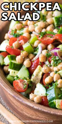 chickpea salad in a wooden bowl with lemon wedges and garnish