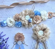 some flowers and ribbons on a white wooden table with blue, beige and brown decorations