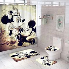 the bathroom is decorated with mickey and minnie mouse shower curtain, rugs and toilet paper