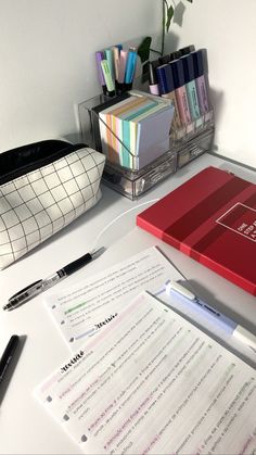 a desk with pens, notebooks and other office supplies