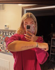 a woman taking a selfie in front of a mirror with her cell phone up to her ear