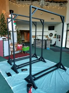 a large metal structure sitting on top of a blue tarp in a room filled with christmas decorations