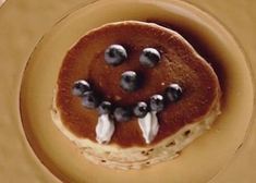 pancakes topped with blueberries and whipped cream on a plate