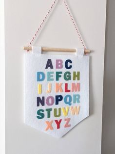 a white wall hanging with letters and numbers on it