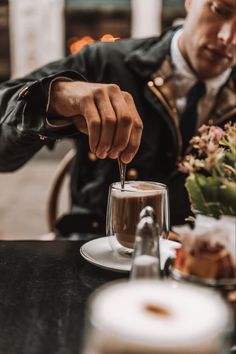 a man sitting at a table with a cup of coffee