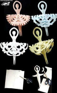 some paper cut outs and scissors on a black surface with white papers next to them