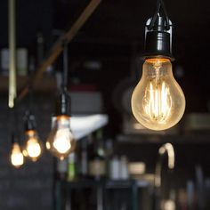 three light bulbs hanging from the ceiling in a kitchen