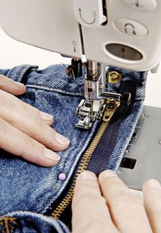 someone using a sewing machine to sew jeans