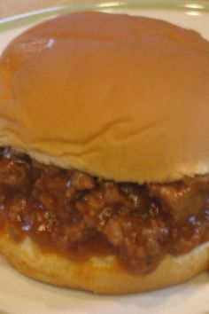 a sloppy joe sandwich sitting on top of a white plate