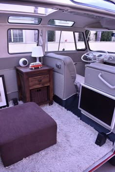 the inside of a vehicle with a bed, desk and television on it's side